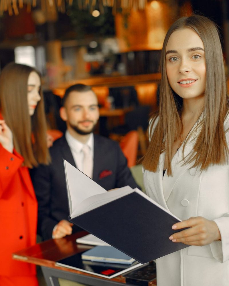 Man and two beautiful women working. People in a cafe. Women in a elegant suit cases